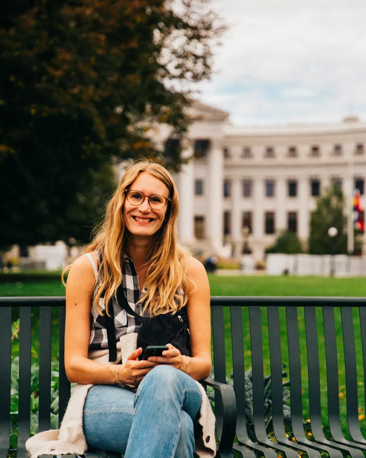 Sofie Amalie Sandstrøm sidder på en bænk foran en hvid bygning i København